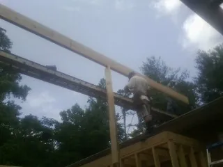 Carpenter setting a ridge beam over a new addition frame — Ice Dam Removal by Roofing Brothers in Piney Creek