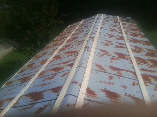 Rusted metal roof panels with new wood purlins before replacement — Storm Damage Roof Repair in Piney Creek by Roofing Brothers