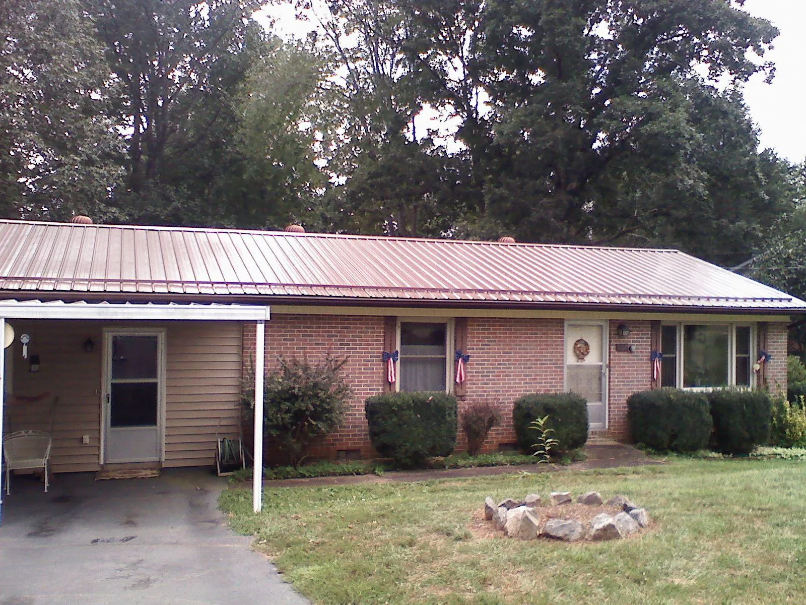 Bronze metal roof and carport on a brick ranch home — Roof Repair work by our crew in Piney Creek